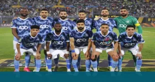 لاعبو فريق بيراميدز يحتفلون بالفوز بكأس أفريقيا، مع شعار البطولة في الخلفية.