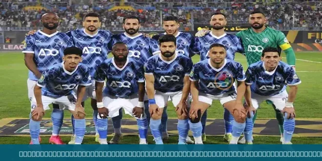 لاعبو فريق بيراميدز يحتفلون بالفوز بكأس أفريقيا، مع شعار البطولة في الخلفية.